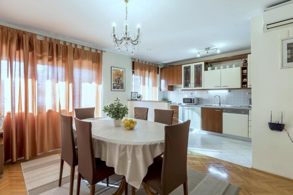 - une cuisine et une salle à manger avec une table et des chaises dans l'établissement Apartments Amari, à Kaštela