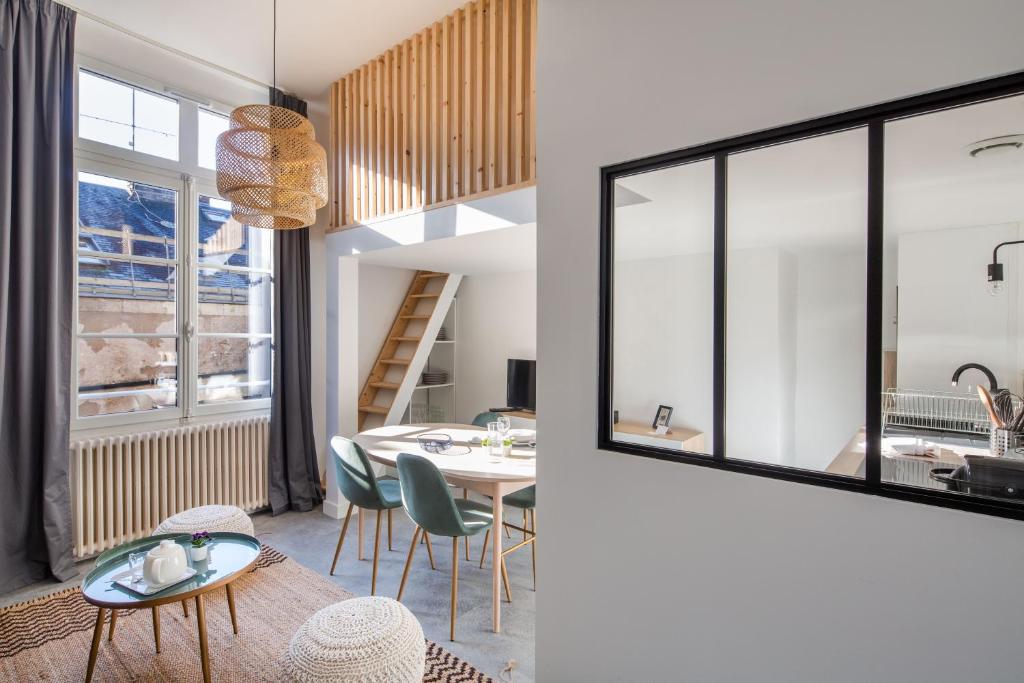 uma sala de estar e de jantar com mesa e cadeiras em Le Pommeraye - Coeur de ville em Nantes