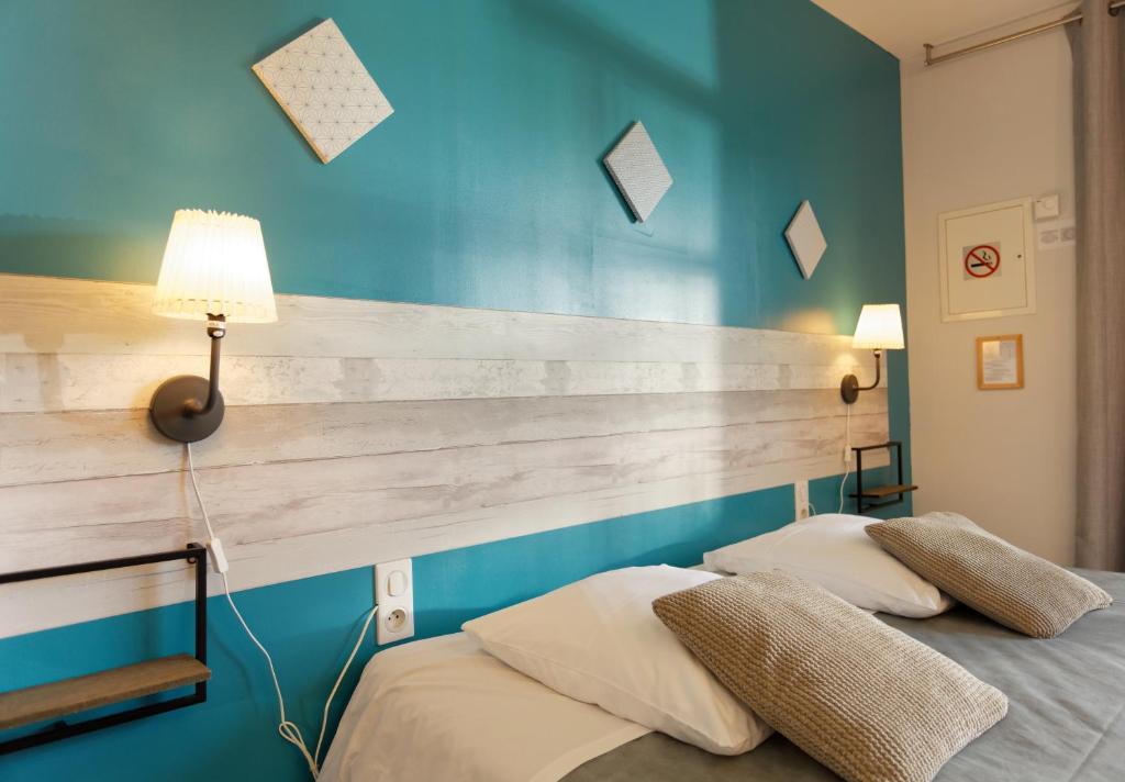 two beds in a bedroom with a wooden headboard at Hotel La Peyrade in Cajarc