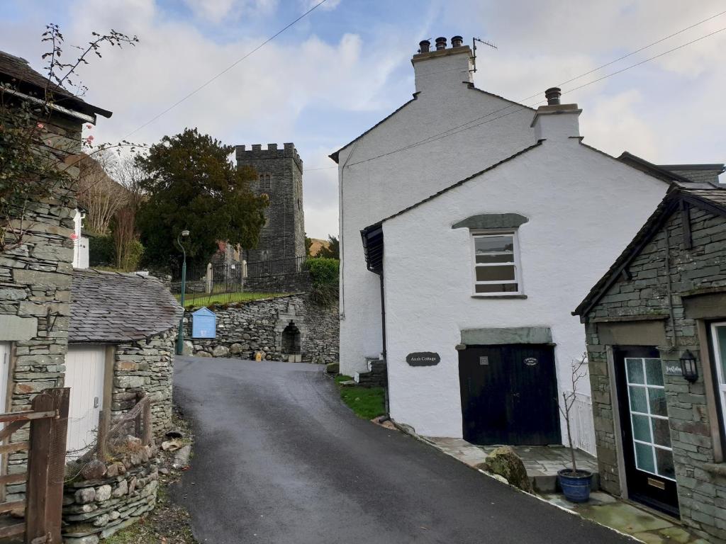 a small white house on a street with buildings at Anns Cottage, Chapel Stile in Chapel Stile
