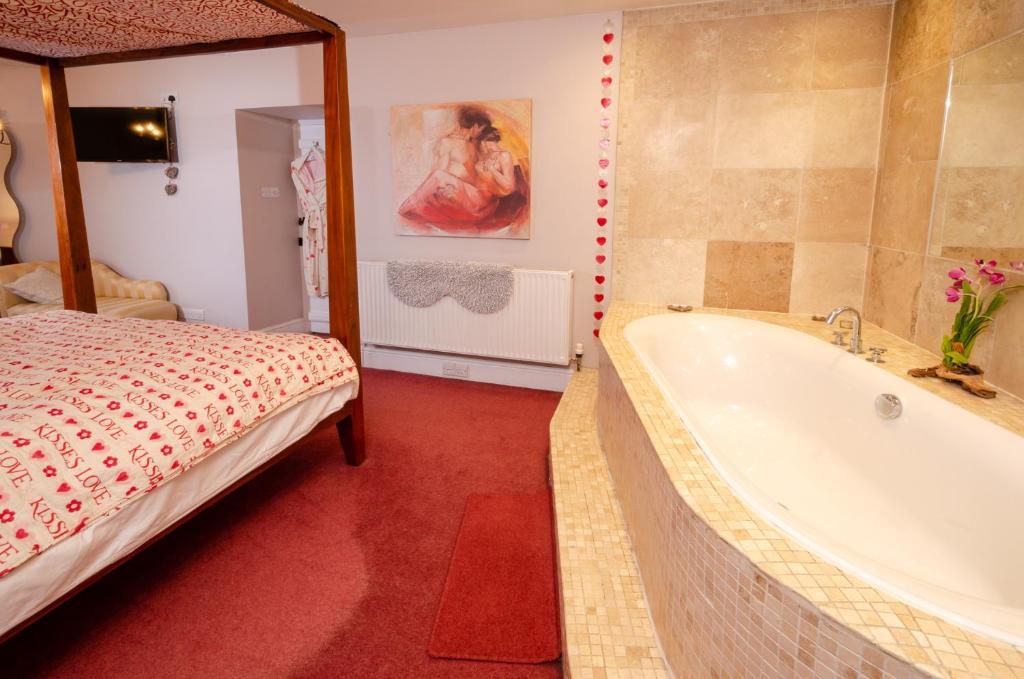 ein Bad mit einer Badewanne und einem Bett darin in der Unterkunft Valentine Cottage in Ambleside
