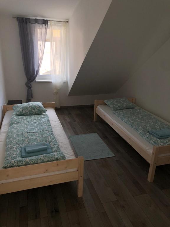 two beds in a room with a window at Good times apartmán & wellness in Žilina