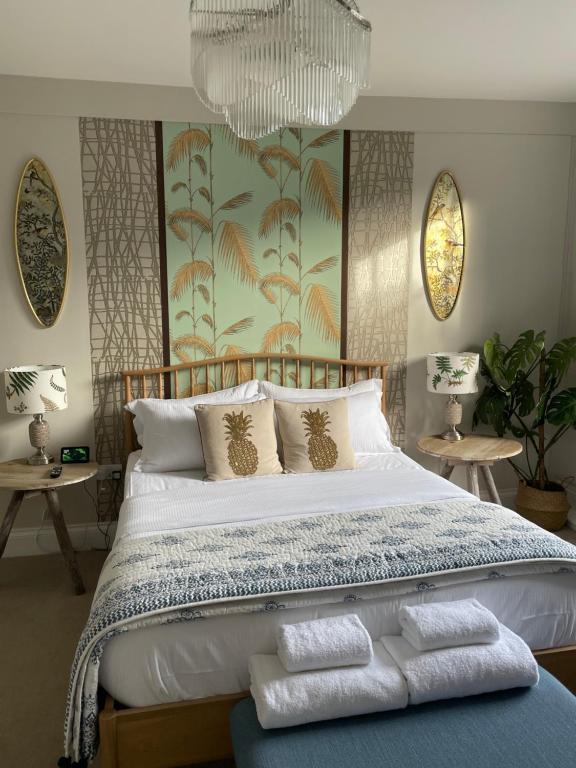 a bedroom with a large bed with a chandelier at The Cross Keys Sherborne in Sherborne