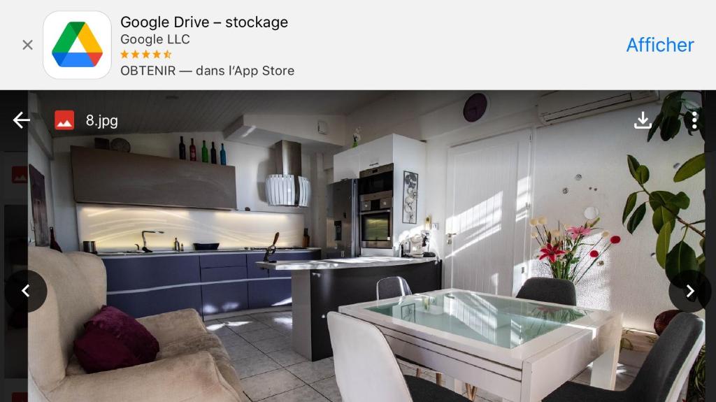 eine Küche mit einem Tisch und einer Küchenzeile mit einem Kühlschrank und einer Kaffeemaschine in der Unterkunft Les jardins de launaguet in Launaguet