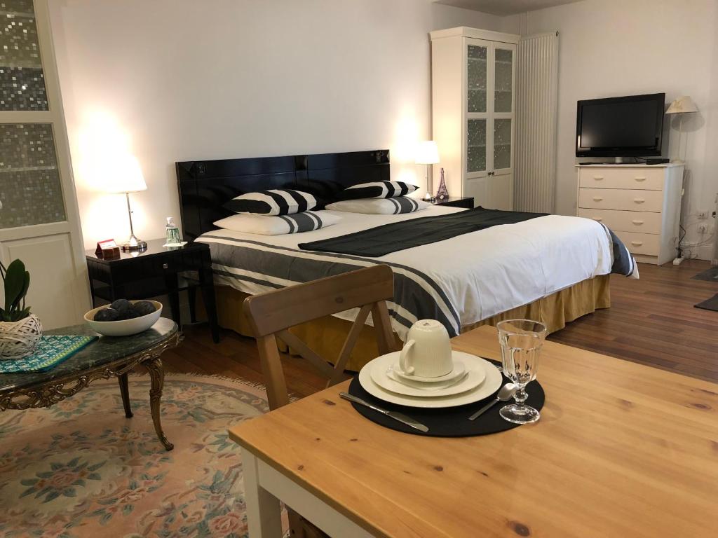 ブリ・シュル・マルヌにあるChambre d'hôtes Chez Mariléのベッドルーム1室(ベッド1台、テーブル、帽子付)