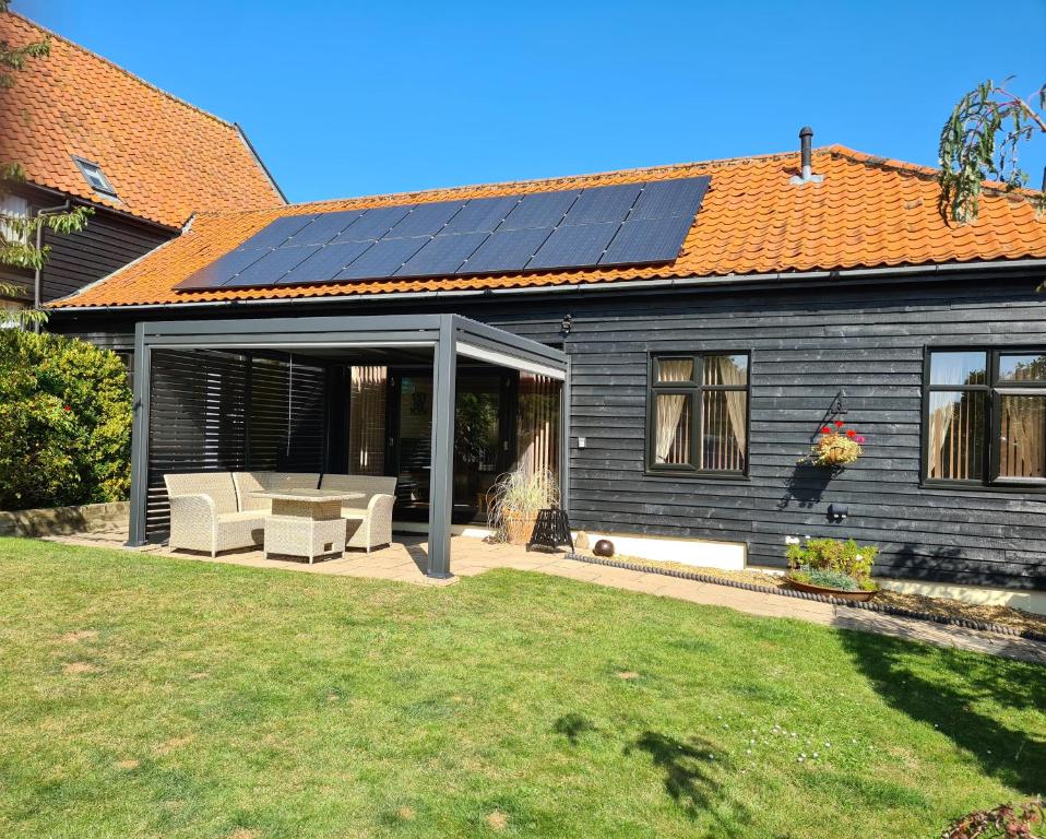 uma casa com painéis solares no telhado em Owl Barn Sisland - spacious apartment em Norwich