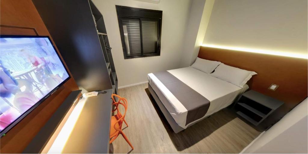 een kleine kamer met een bed en een televisie bij Best Guest Hotel Expo Anhembi in Sao Paulo