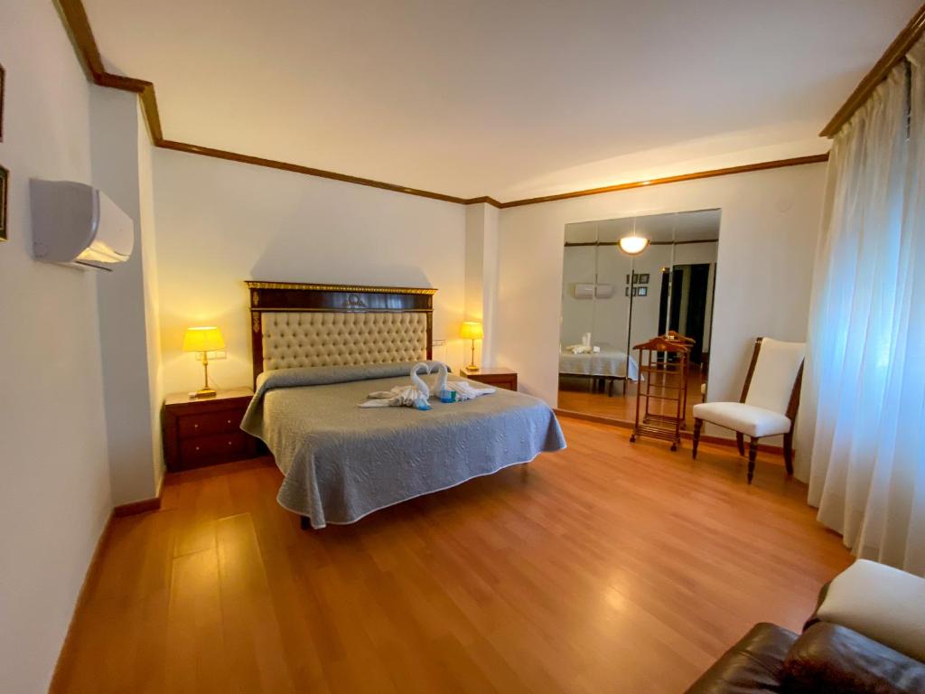 1 dormitorio con 1 cama y 1 silla en Hotel Cardinal, en Albacete