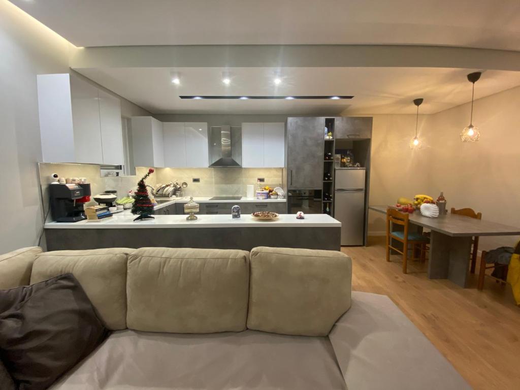 a living room with a couch in front of a kitchen at Villa Panorama - 3 Bedrooms Sea View - Free Parking in Sarandë