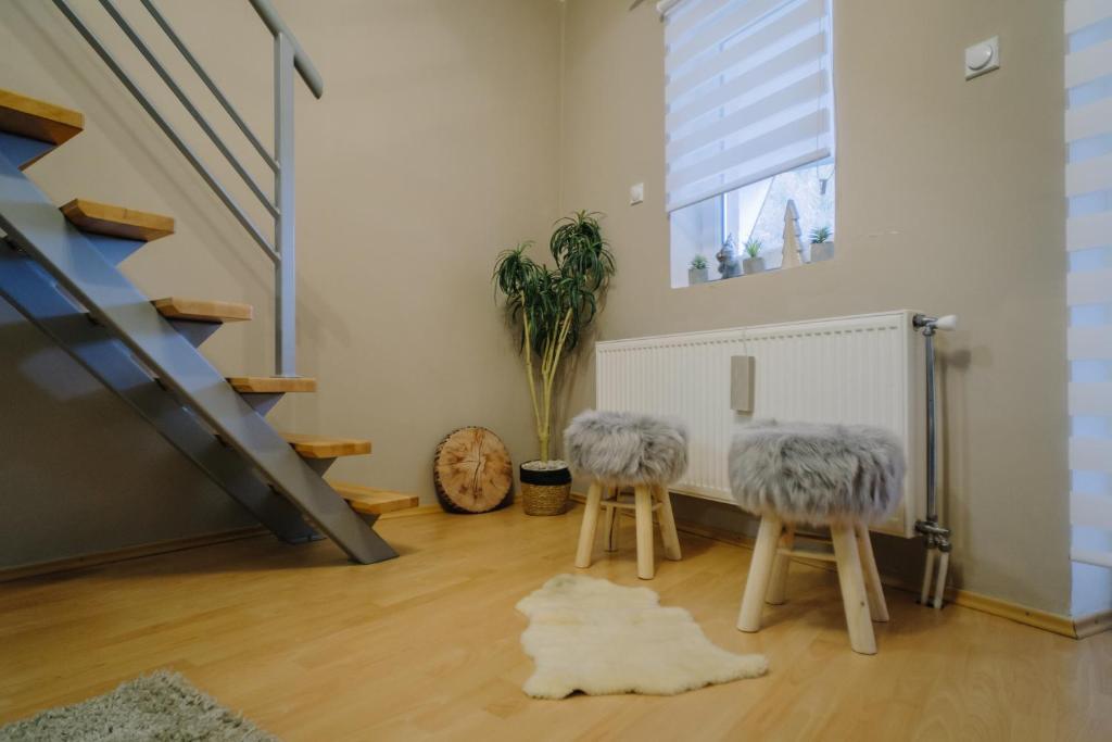 a living room with two stools and a staircase at Košuta 21 Center Duplex Apartment, Brzeće in Brzeće