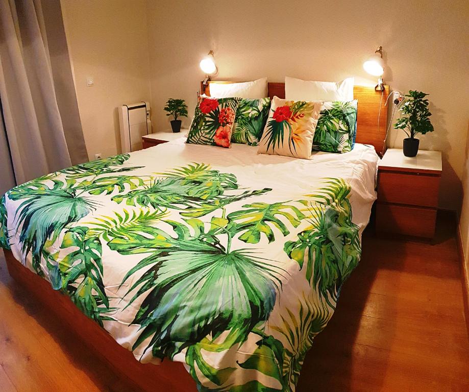 a bedroom with a large bed with a tropical print at Mermaid House- pareado boutique - playa a 200m- pases para piscina externa in Chiclana de la Frontera