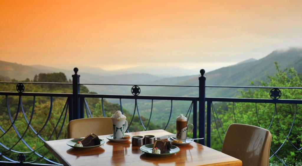 una mesa con comida y vistas a las montañas en Magoebaskloof Hotel, en Tzaneen