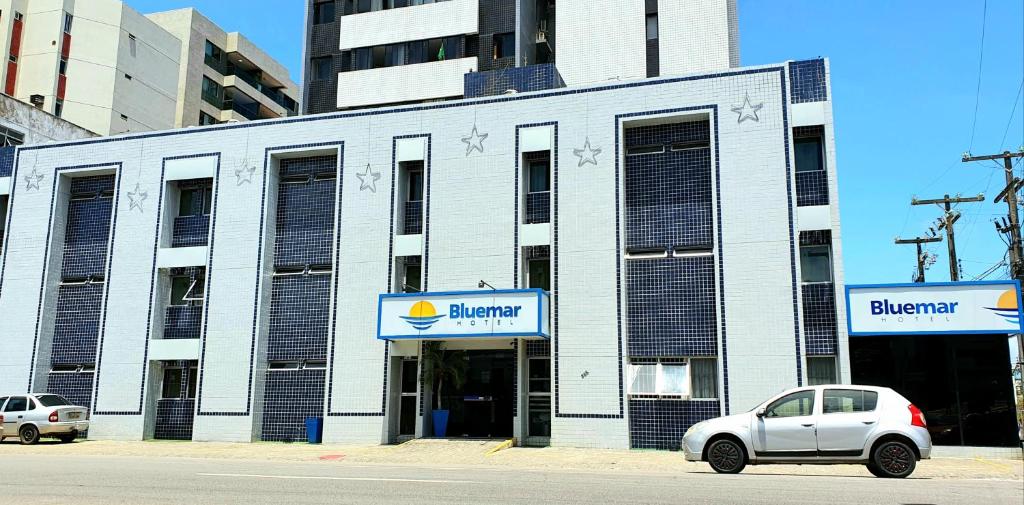 um carro branco estacionado em frente a um edifício em Bluemar Hotel em Maceió