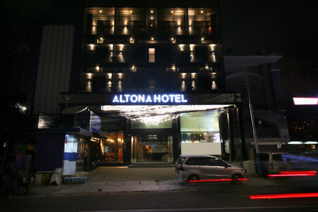 雅加達的住宿－Altona Hotel，晚上停在酒店门前的汽车