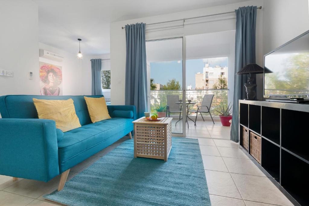 sala de estar con sofá azul y mesa en Glabur Stays - The Cozy Atelier - Nicosia City, Free Parking & Wifi, Welcomes You!!!, en Nicosia