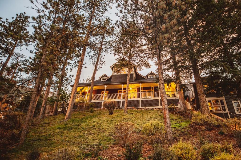 uma casa no topo de uma colina com árvores em The Outlook Lodge em Green Mountain Falls