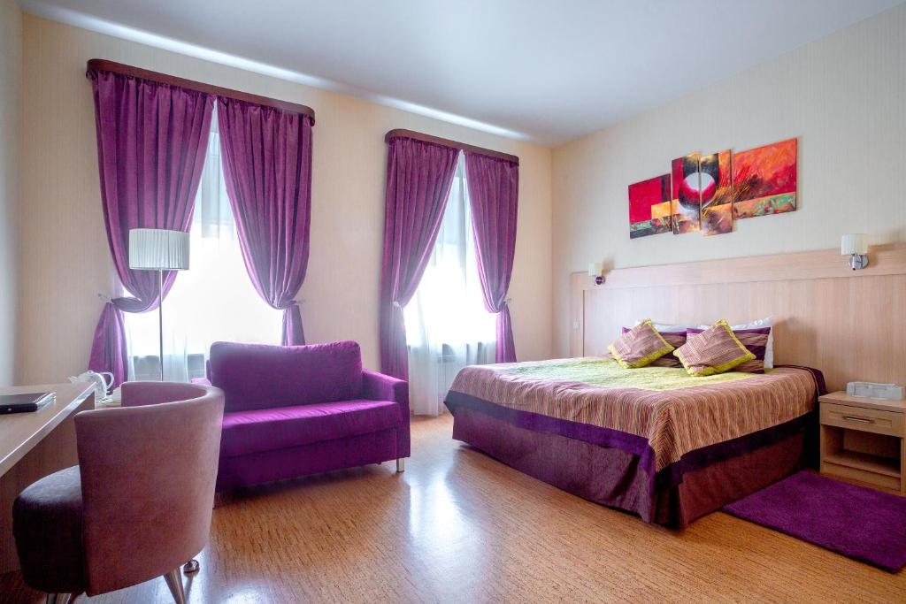 1 dormitorio con cortinas moradas, 1 cama y 1 silla en Herzen House en San Petersburgo