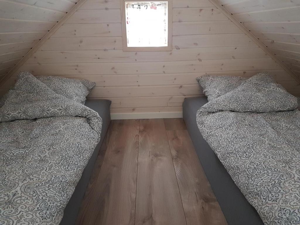 two beds in a attic bedroom with a window at Small Paradise in Sørvágur