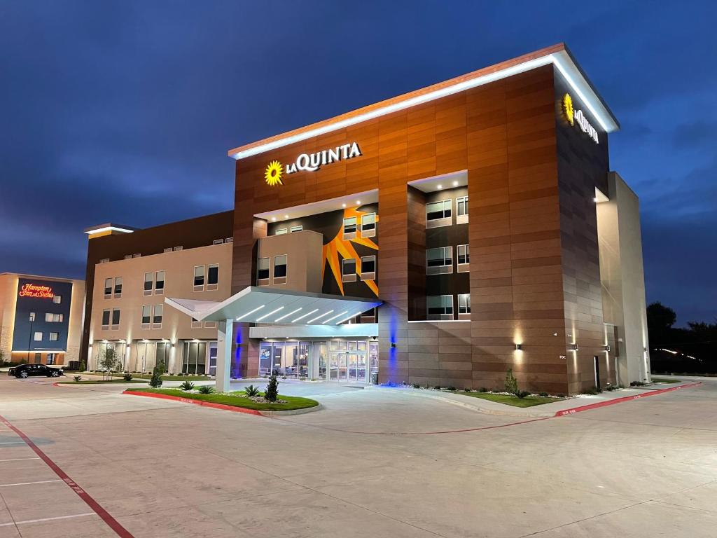 a building with a sign on the front of it at La Quinta Inn & Suites by Wyndham Dallas/Fairpark in Dallas