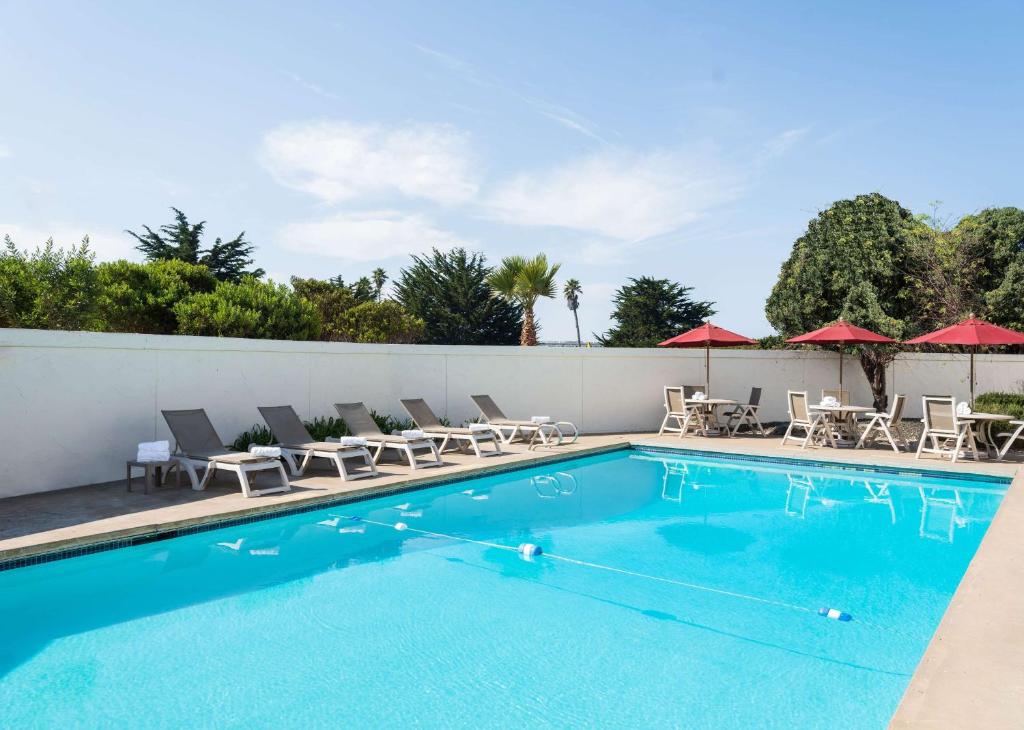 a swimming pool with chairs and umbrellas at Motel 6 San Simeon, CA - Hearst Castle Area in San Simeon