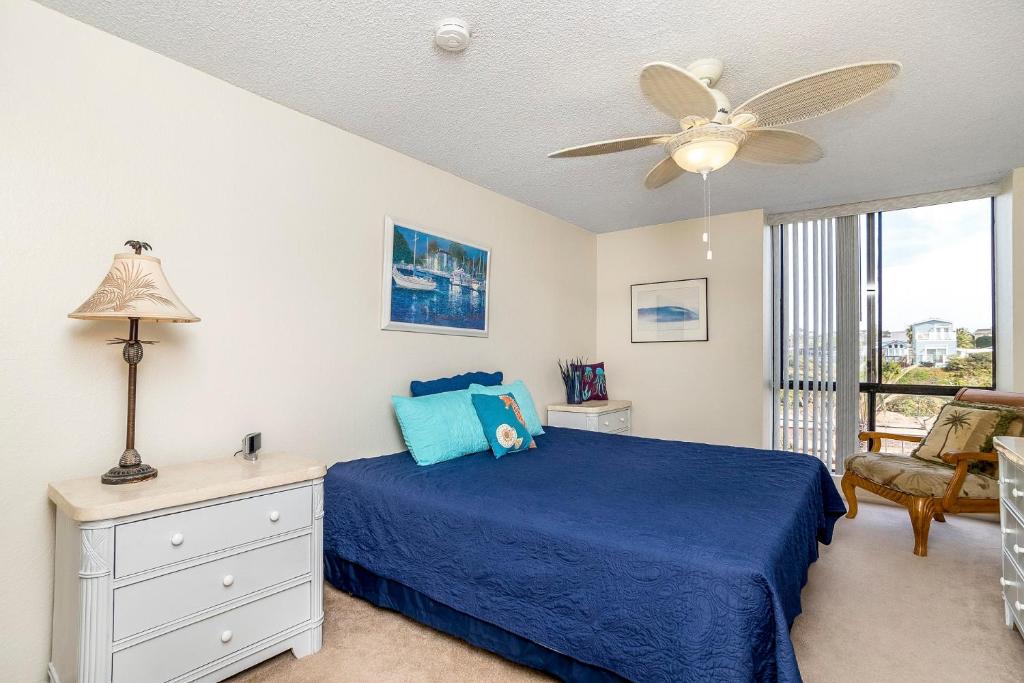 a bedroom with a blue bed and a ceiling fan at Condo in Beachfront Resort B-212 in Oceanside