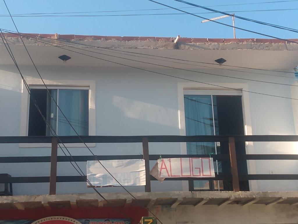 - un balcon dans un bâtiment blanc avec un banc rouge dans l'établissement Suíte Familiar, à Arraial do Cabo