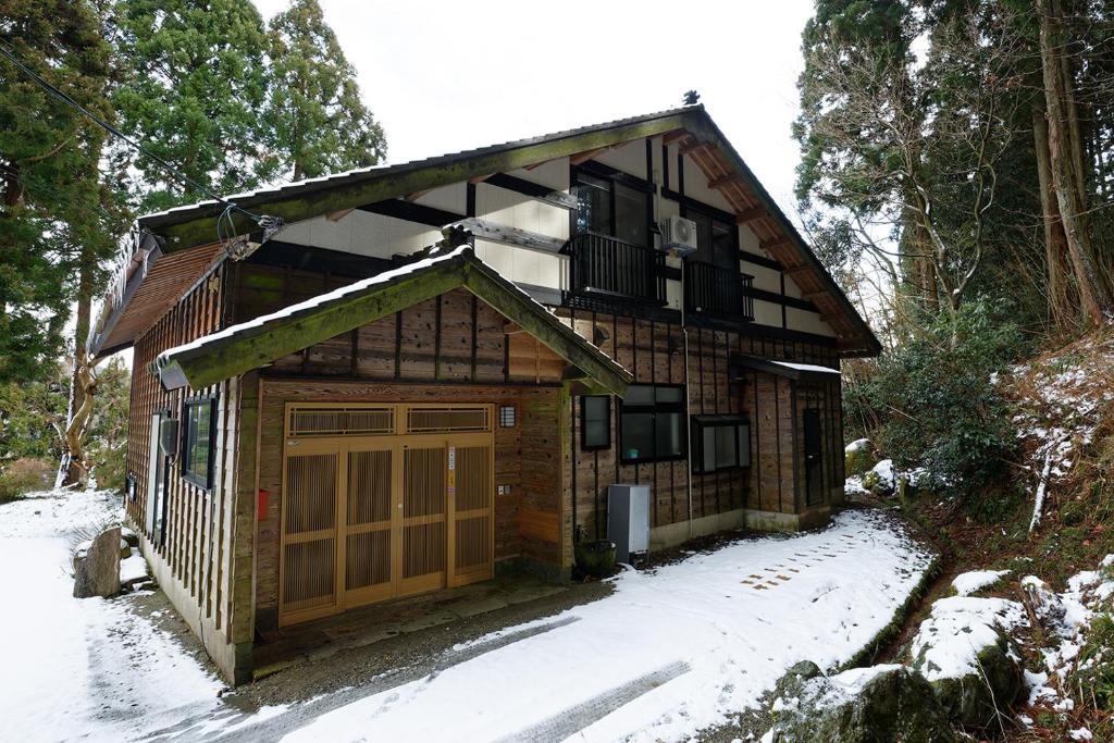 a house with a garage in the snow at 能生の家 in Itoigawa