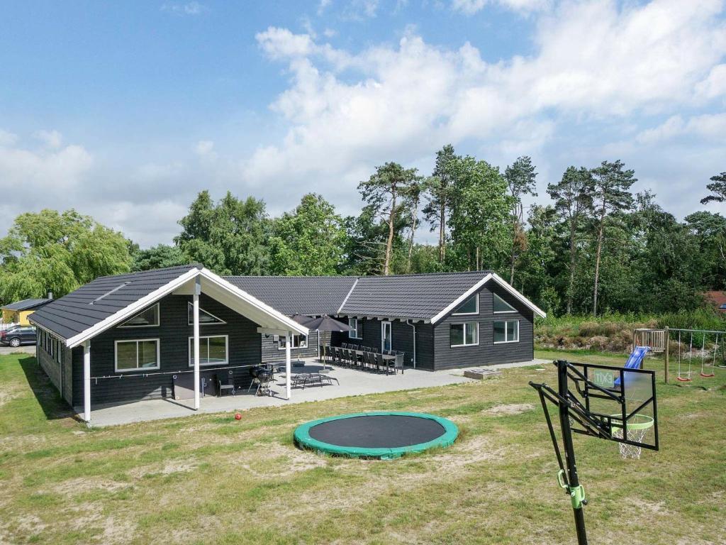 una pequeña casa con una cama elástica delante de ella en 22 person holiday home in Nex, en Bedegård