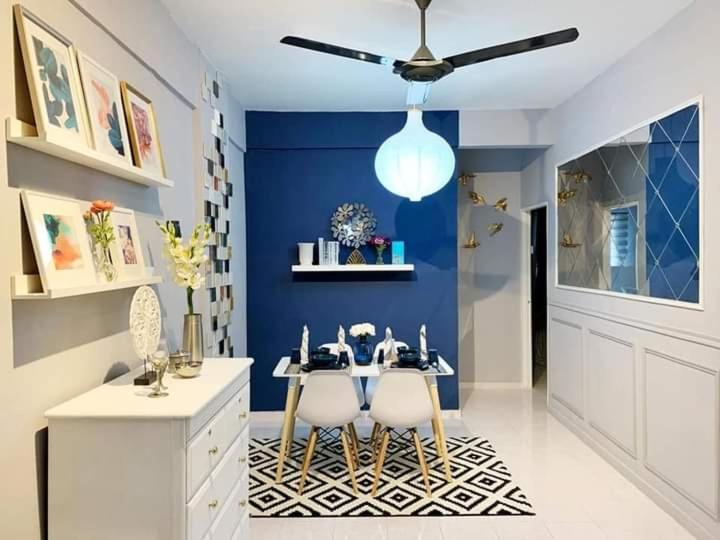 a dining room with a table and a blue wall at Maya Homestay Putrajaya Unit Dua in Putrajaya