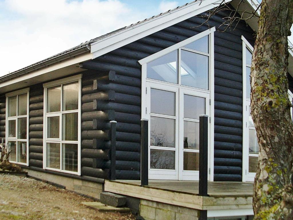 una casa nera con finestre bianche e un albero di 8 person holiday home in B rkop a Børkop