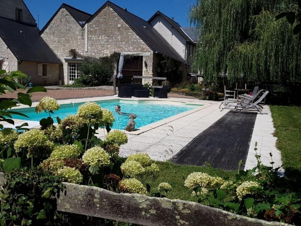 a swimming pool in the backyard of a house at Former customs house with large garden and private pool 4 km from Chinon in La Roche-Clermault