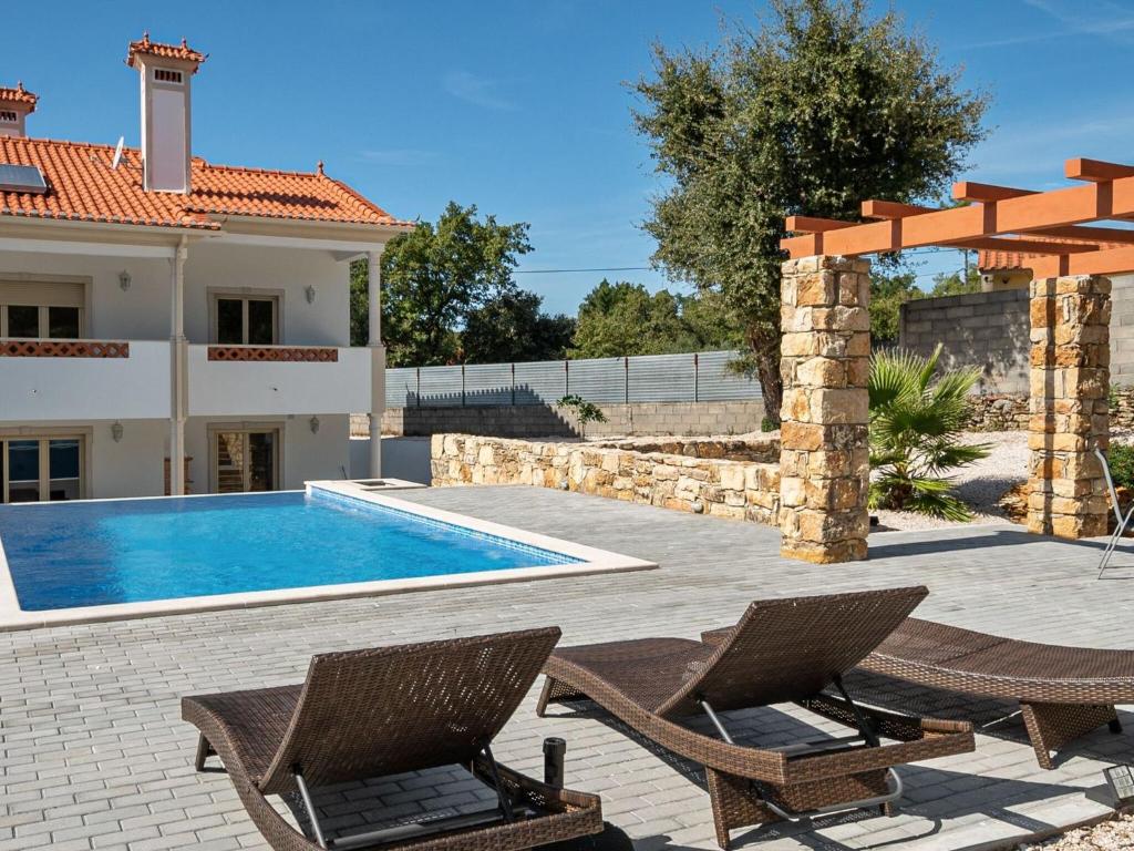 a villa with a swimming pool and two chairs at Wonderful villa in Ferreira do Zezere with private pool in Almogade