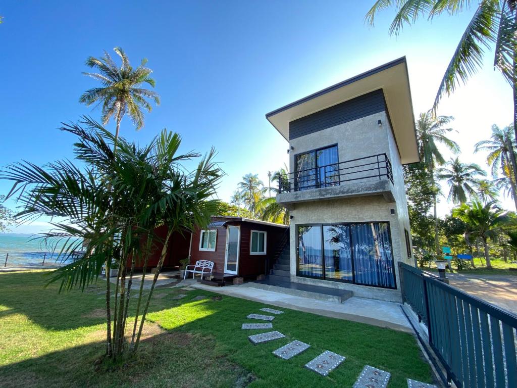 a house with a balcony and the ocean in the background at Somphoch Garden in Trat