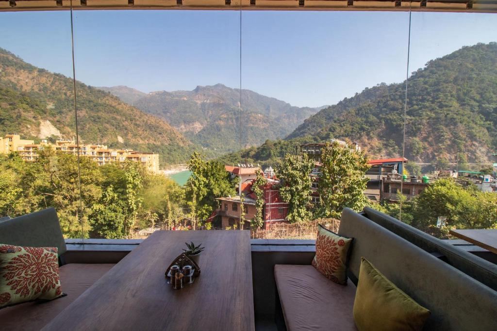 um quarto com uma mesa e vista para uma montanha em Punyah Residency Rishikesh em Rishikesh