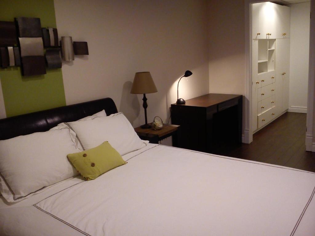 a bedroom with a white bed with a yellow pillow on it at Appartement Bellevue in Saint-Félicien