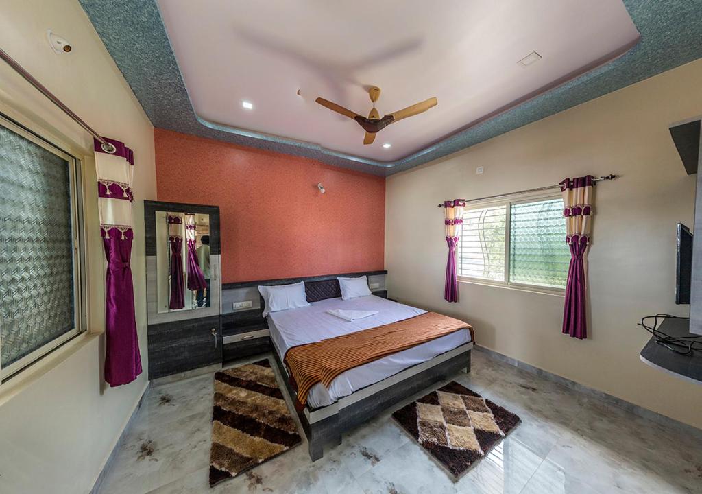 um quarto com uma cama e uma ventoinha de tecto em Krishna Homestay Hampi em Hampi