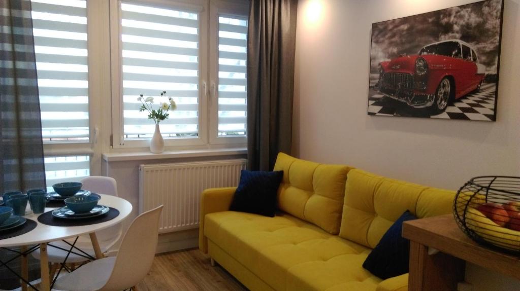 a living room with a yellow couch and a red car at Apartament u Gosi! in Giżycko
