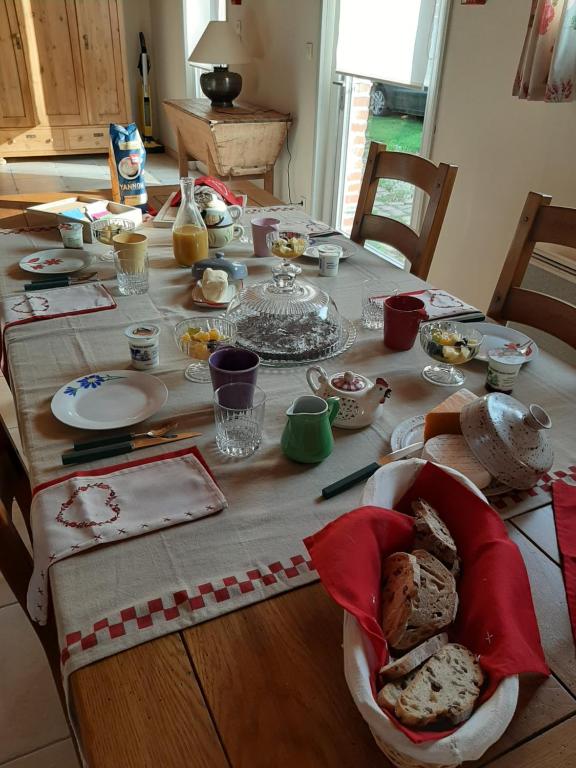 uma mesa com comida e pratos em cima dela em Ferme des capucines 