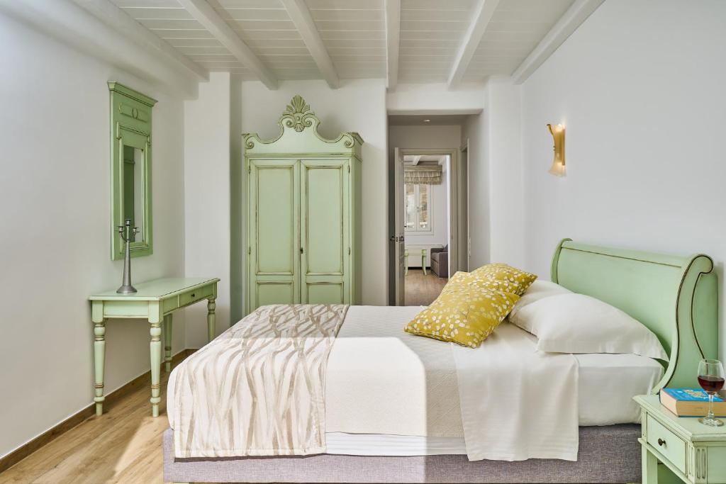 a bedroom with a bed and a table and a desk at Arte & Mare Elia Luxury Suites and Villas in Elia Beach