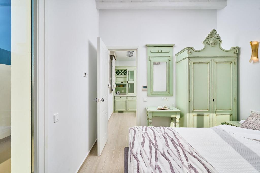 a bedroom with a bed and a dressing room at Arte & Mare Elia Luxury Suites and Villas in Elia Beach