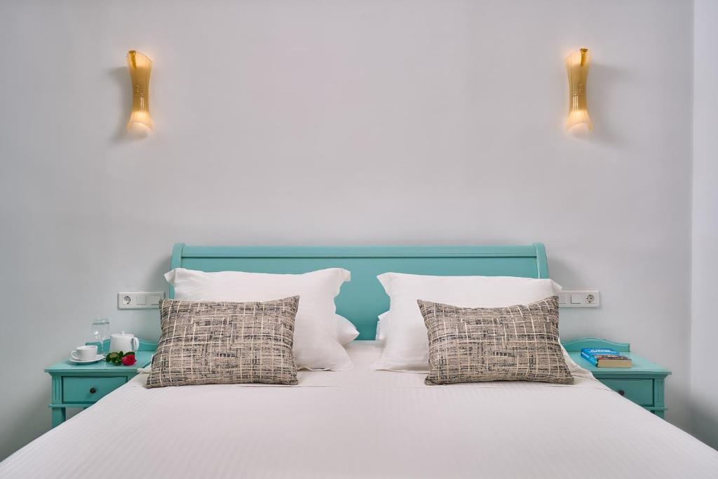 a bedroom with a blue and white bed with pillows at Arte & Mare Elia Luxury Suites and Villas in Elia Beach