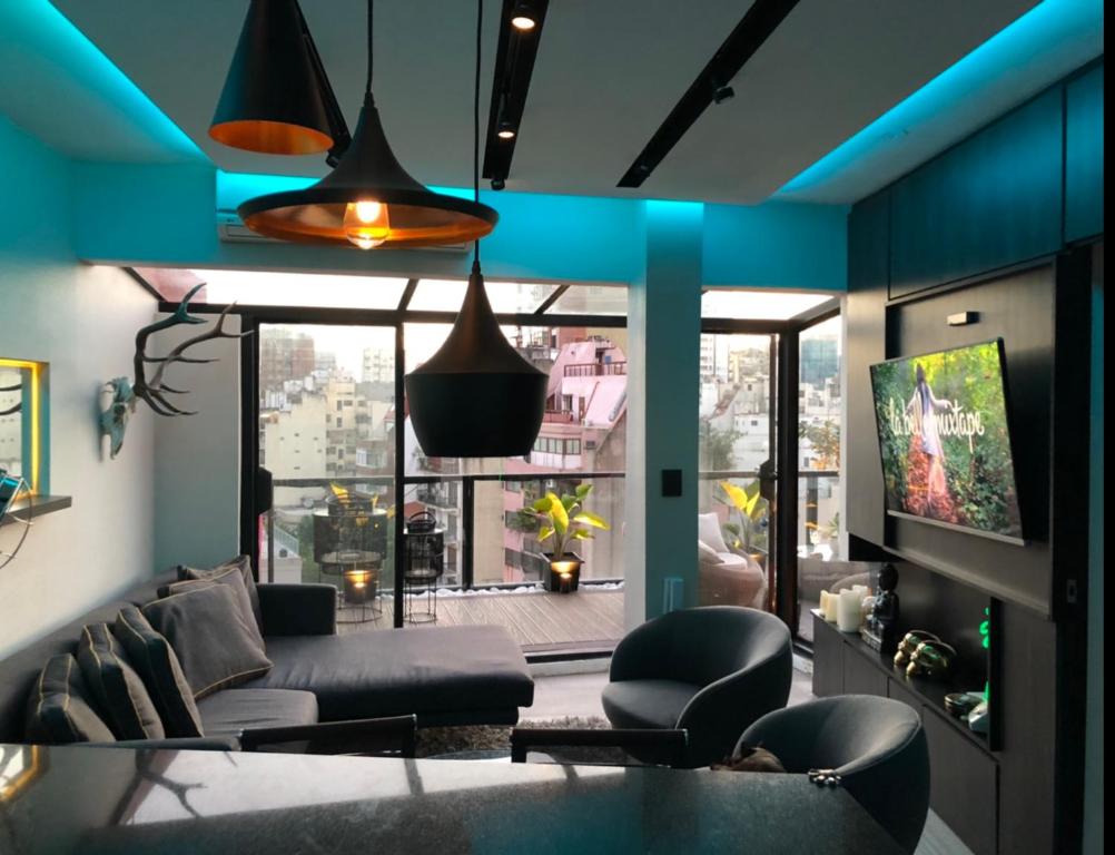 a living room with a couch and a tv at GATE Recoleta in Buenos Aires