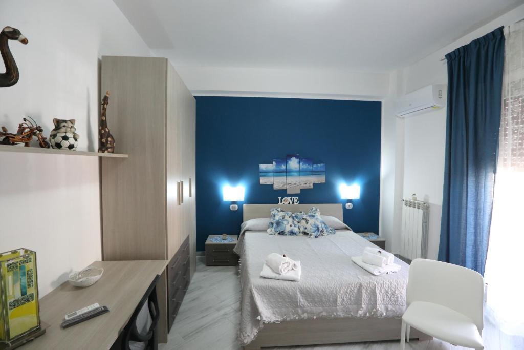 1 dormitorio con cama y pared azul en B&B ANGELO, en Caltanissetta