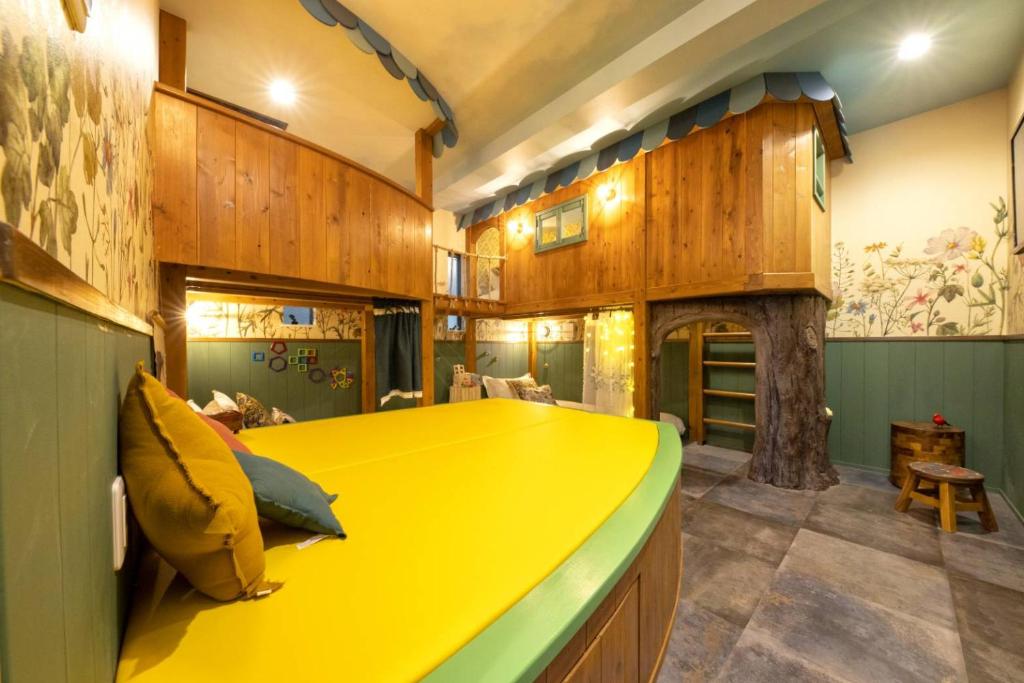 Cette chambre dispose d'un grand lit jaune et de murs en bois. dans l'établissement Holy House, à Tokyo