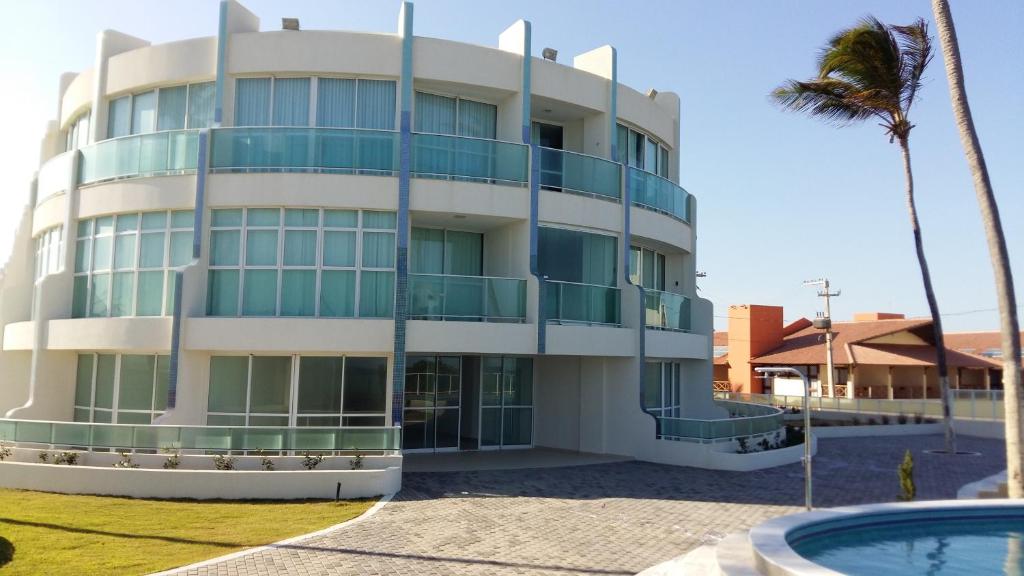un edificio con piscina frente a él en Apto Areias beira-mar, en Barra de São Miguel