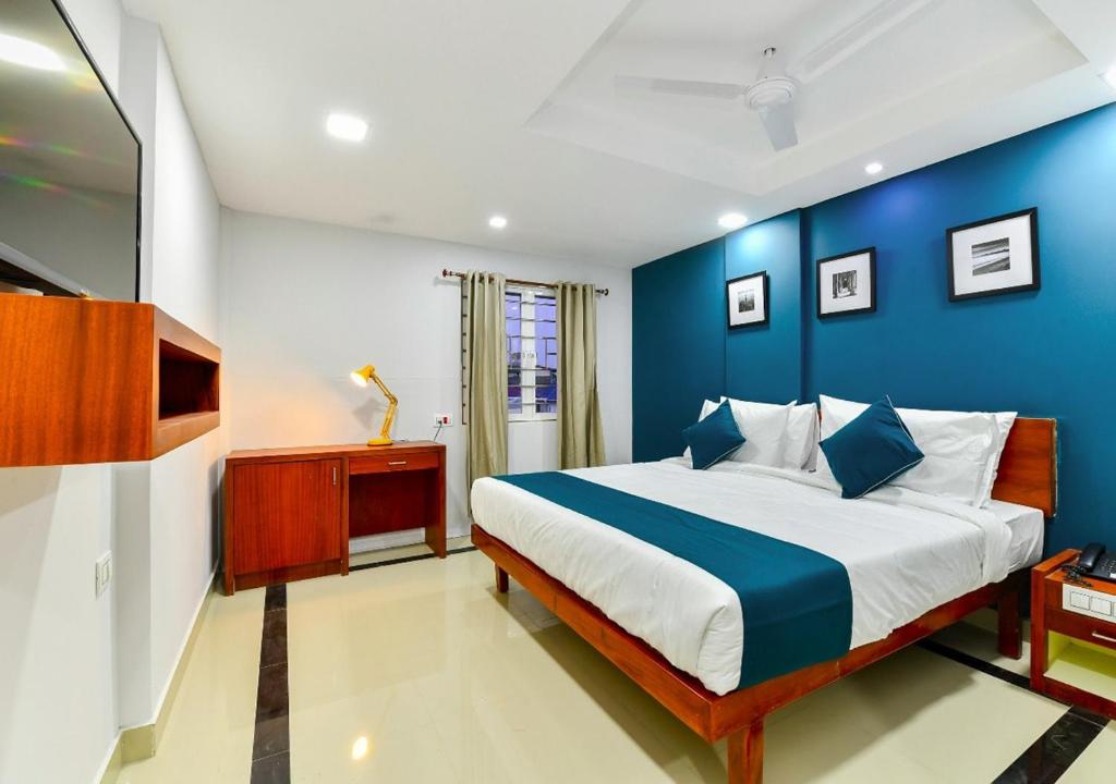 a blue and white bedroom with a large bed at The Reach Hotel in Cochin