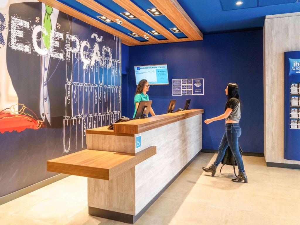 two women standing at a reception counter in a store at ibis budget Sao Caetano in São Caetano do Sul