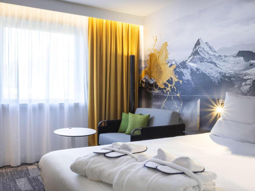 Novotel Annecy Centre في أنِسي: غرفة فندق عليها سرير وفوط