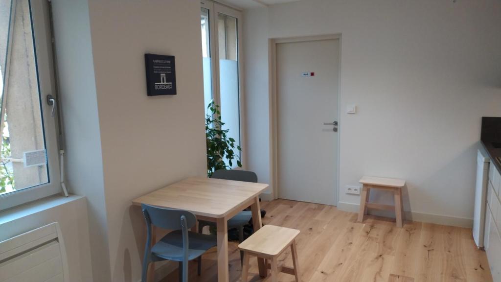a small room with a wooden table and chairs at Appartement rénové centre historique in Bordeaux