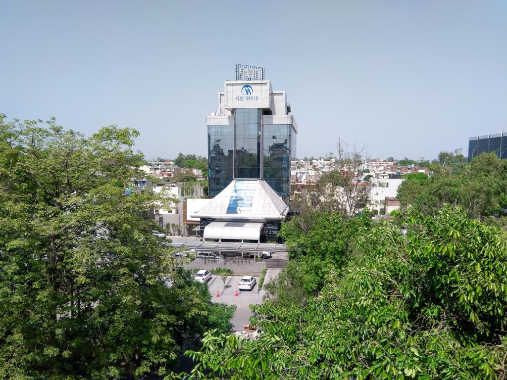 un edificio con una torre de reloj en una ciudad en The Maya Hotel, en Jalandhar